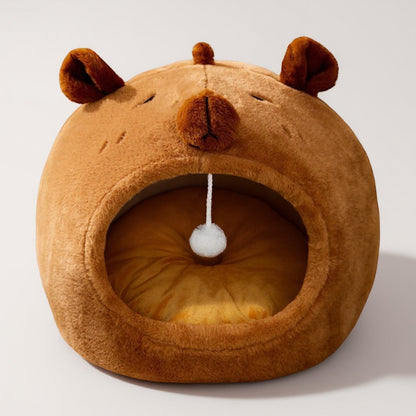 Animoo brown plush bear-shaped pet bed with a dangling pom-pom toy. Soft, enclosed design for comfort and security.